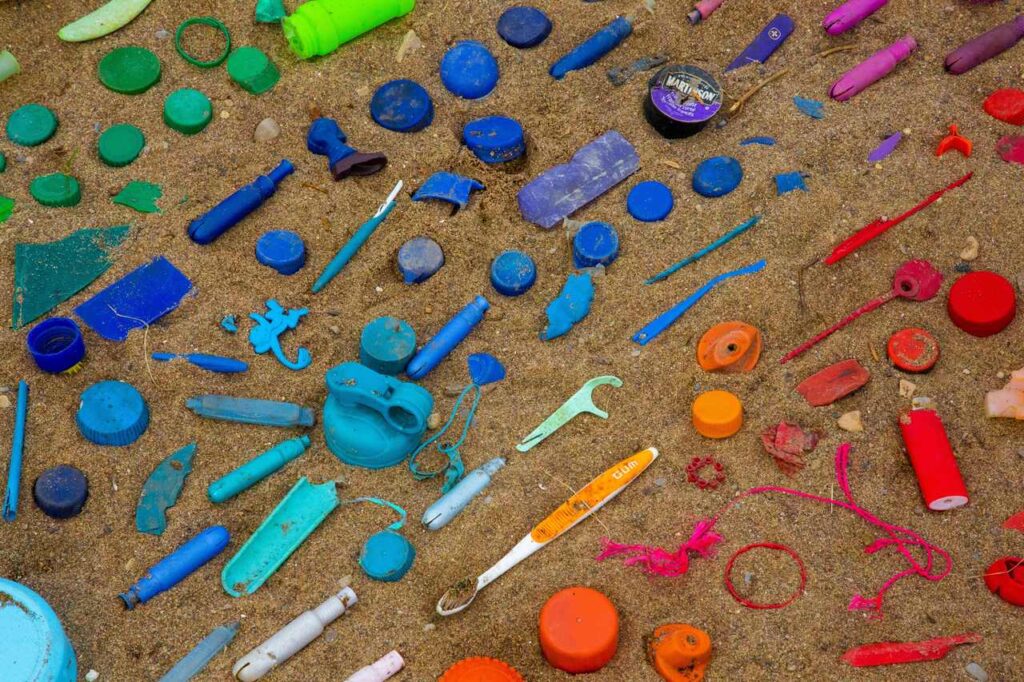 array of plastics on beach sand