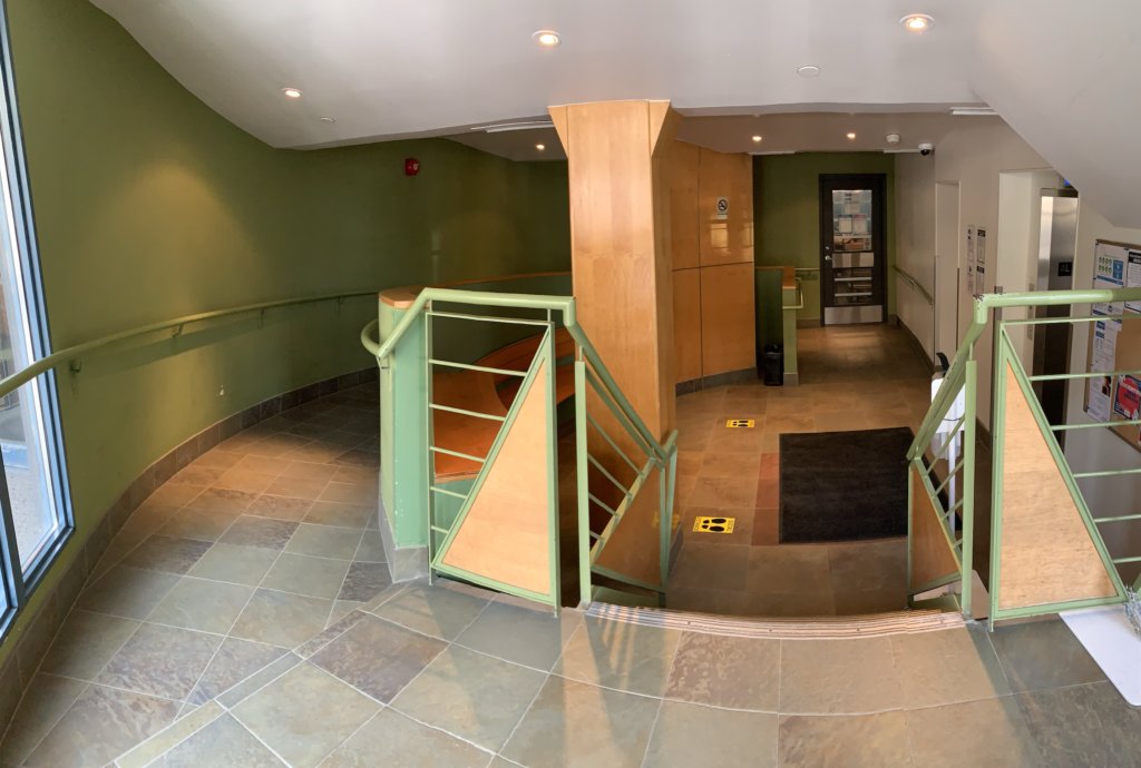 entryway with stairs and accessibility ramp to the elevators